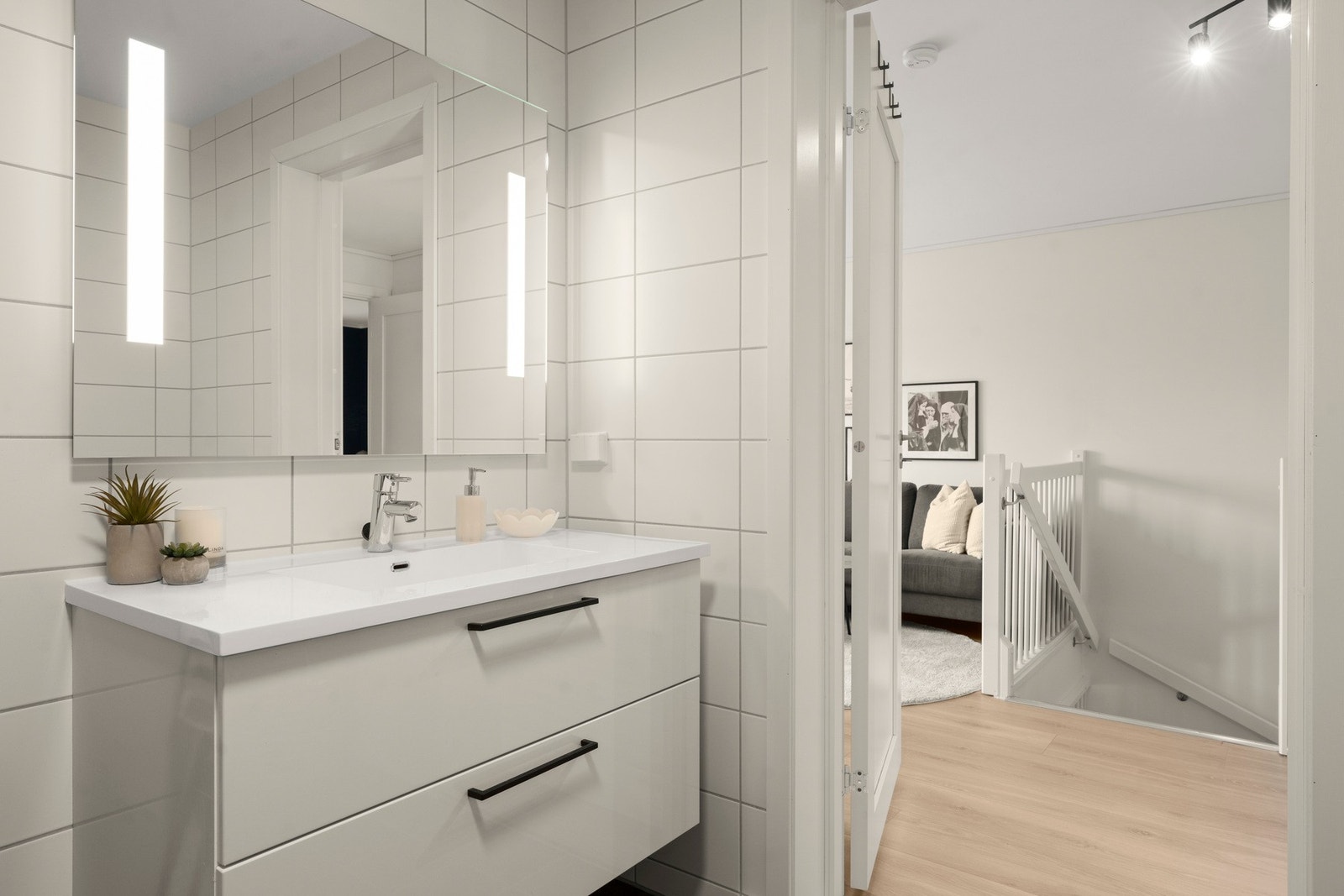 Badet er innredet med bred servantinnredning med god oppbevaringsplass, stort speil med integrert belysning, vegghengt toalett og dusjhjørne med glassdører. Galleribilde
