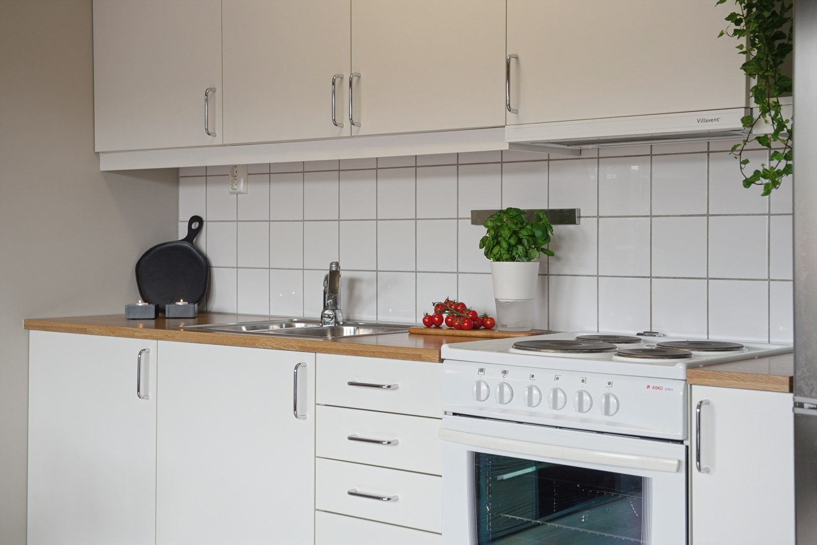 Vegg over benkeplate er flislagt, praktisk ved matlaging. Galleribilde