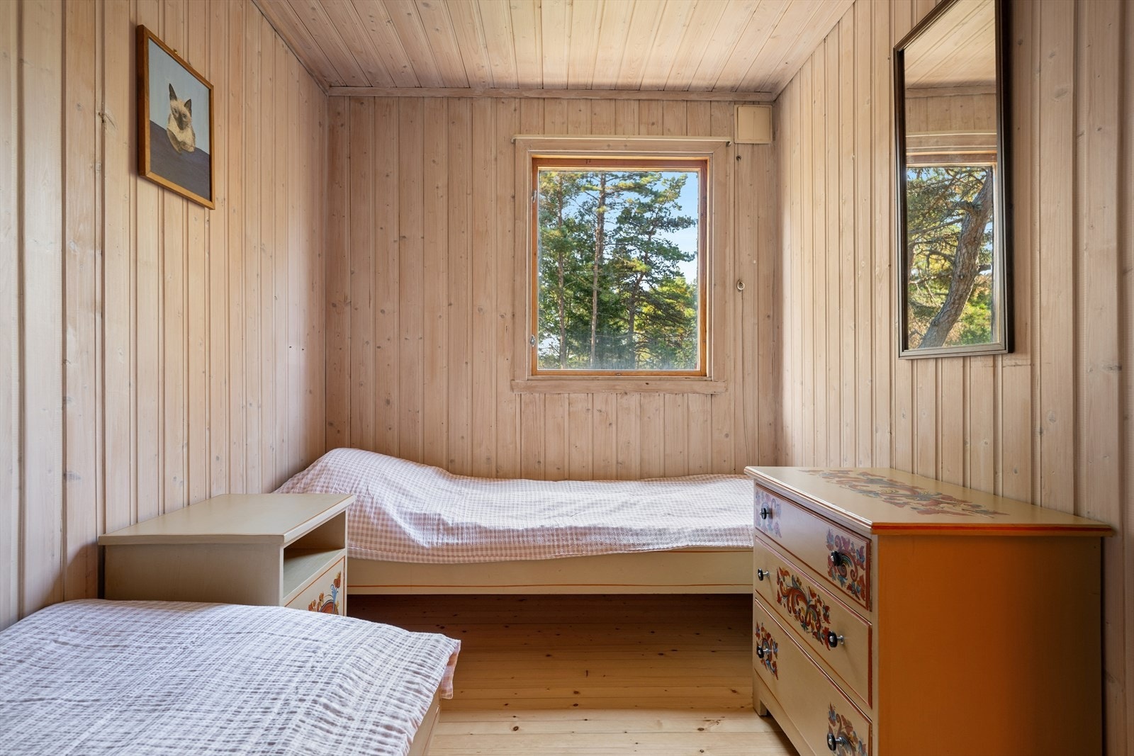 Lyst og trivelig soverom med to sengeplasser og utsyn mot naturen. Hytta har totalt tre soverom, noe som gir gode overnattingsmuligheter for familie og venner. Galleribilde