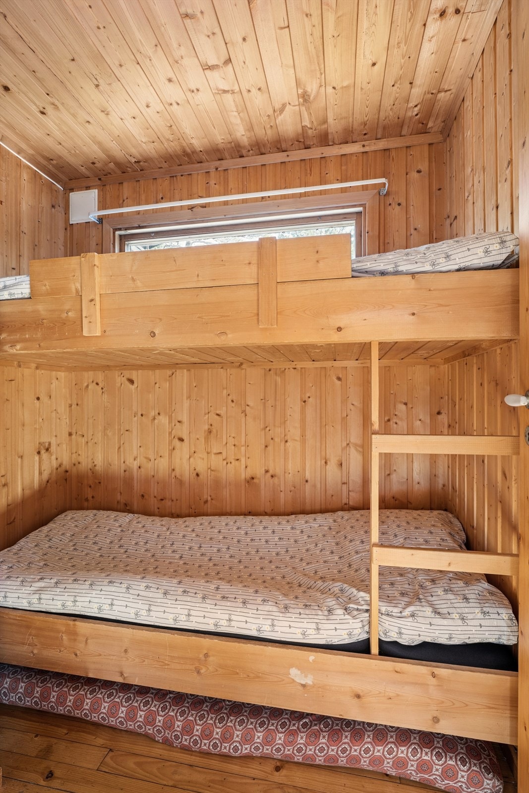 Et av hyttas soverom er innredet med køyeseng og utnytter arealet effektivt - perfekt for barn eller overnattingsgjester. Galleribilde