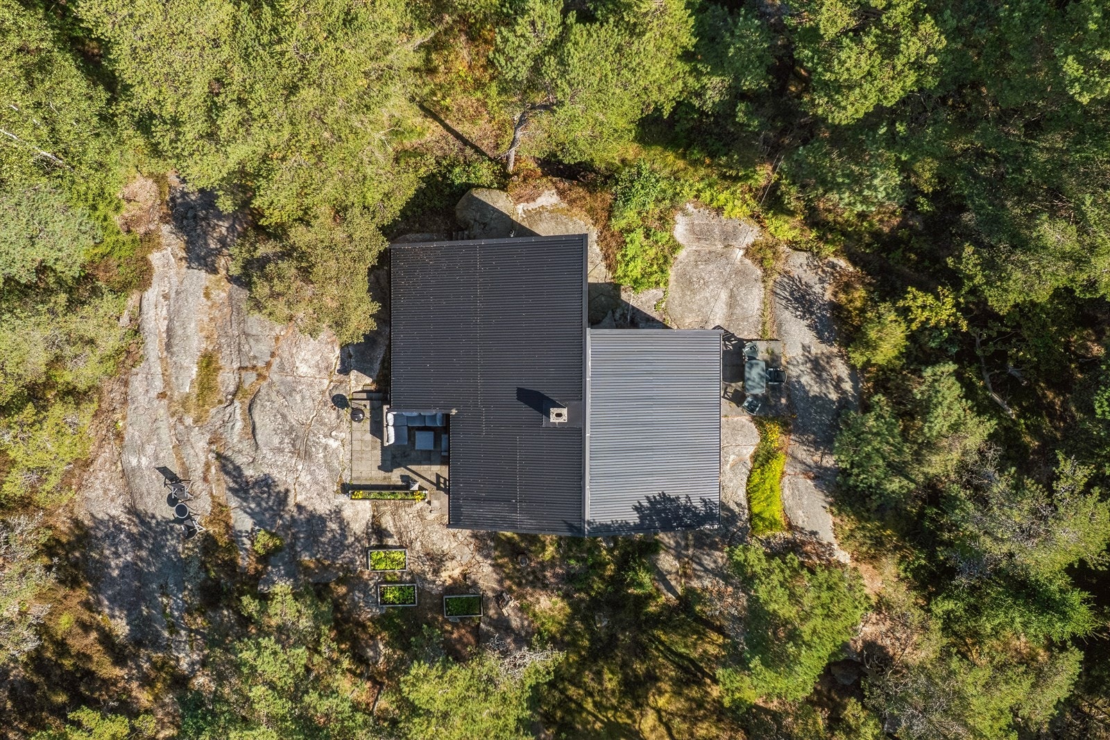 Fra luften ser man hvordan hytta ligger naturlig og skjermet til mellom svaberg og grønn vegetasjon - en klassisk Hvaler-eiendom med naturen tett på. Galleribilde
