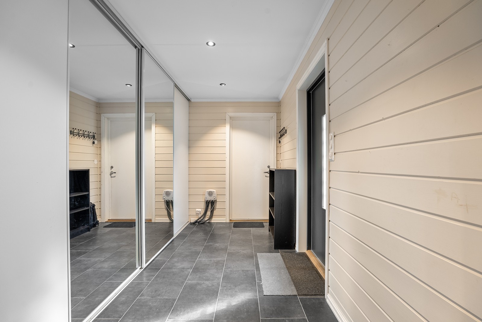Velkommen inn! Flislagt entré med varmekabler i gulvet og praktisk skyvedørsgarderobe med god oppbevaringsplass for jakker og sko. Galleribilde