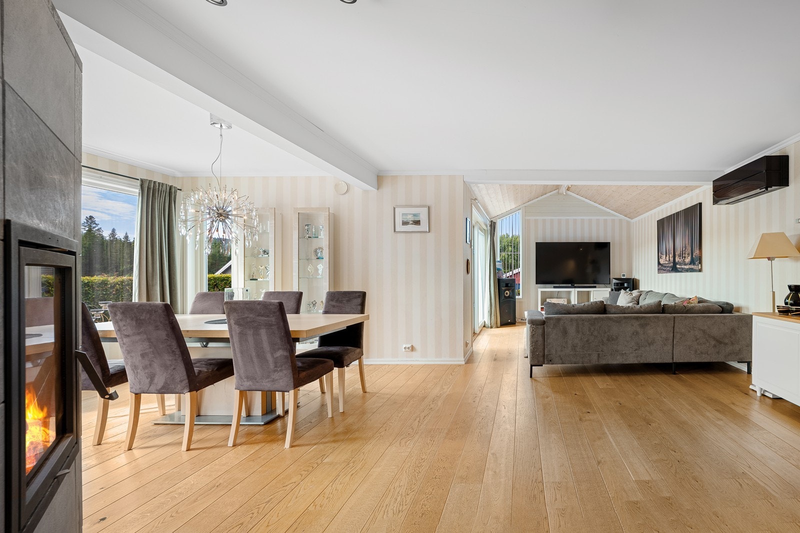 Velkommen inn i stuen. Her blir du møtt av en lun peis som både skaper en hyggelig atmosfære og bidrar med god varme til hele etasjen. Galleribilde