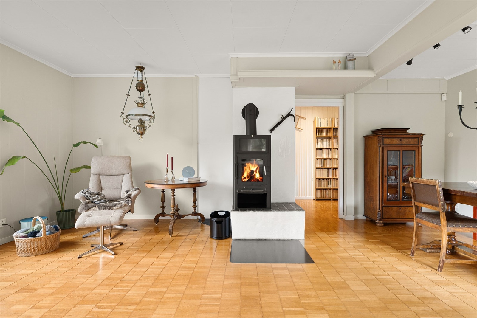 Lyse overflater og klassisk stavparkett på gulvet. Moderne peisovn som gir god varme. Galleribilde