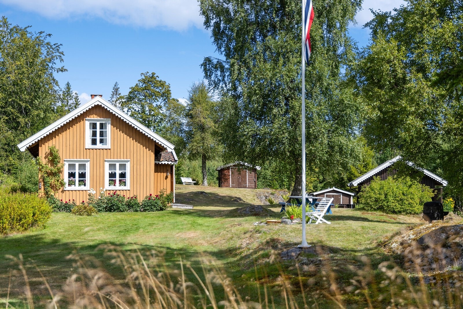 En særpreget tomt med vakre blomsterbed og gjennomtenkte beplantninger som bidrar til et hyggelig utemiljø. Galleribilde