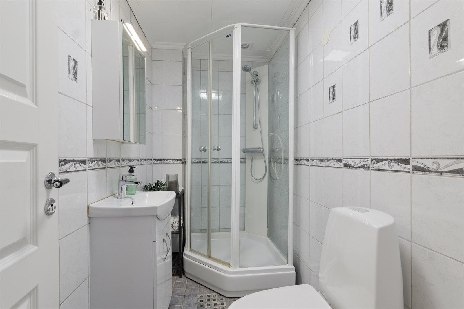 Badet er innredet med servant, toalett og dusjkabinett. Galleribilde
