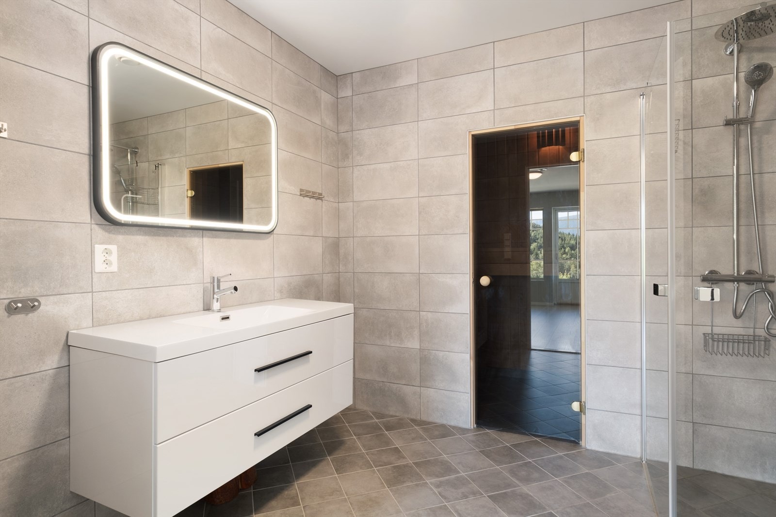 Badet har flislagt golv med elektriske varmekablar og måla himling. Galleribilde