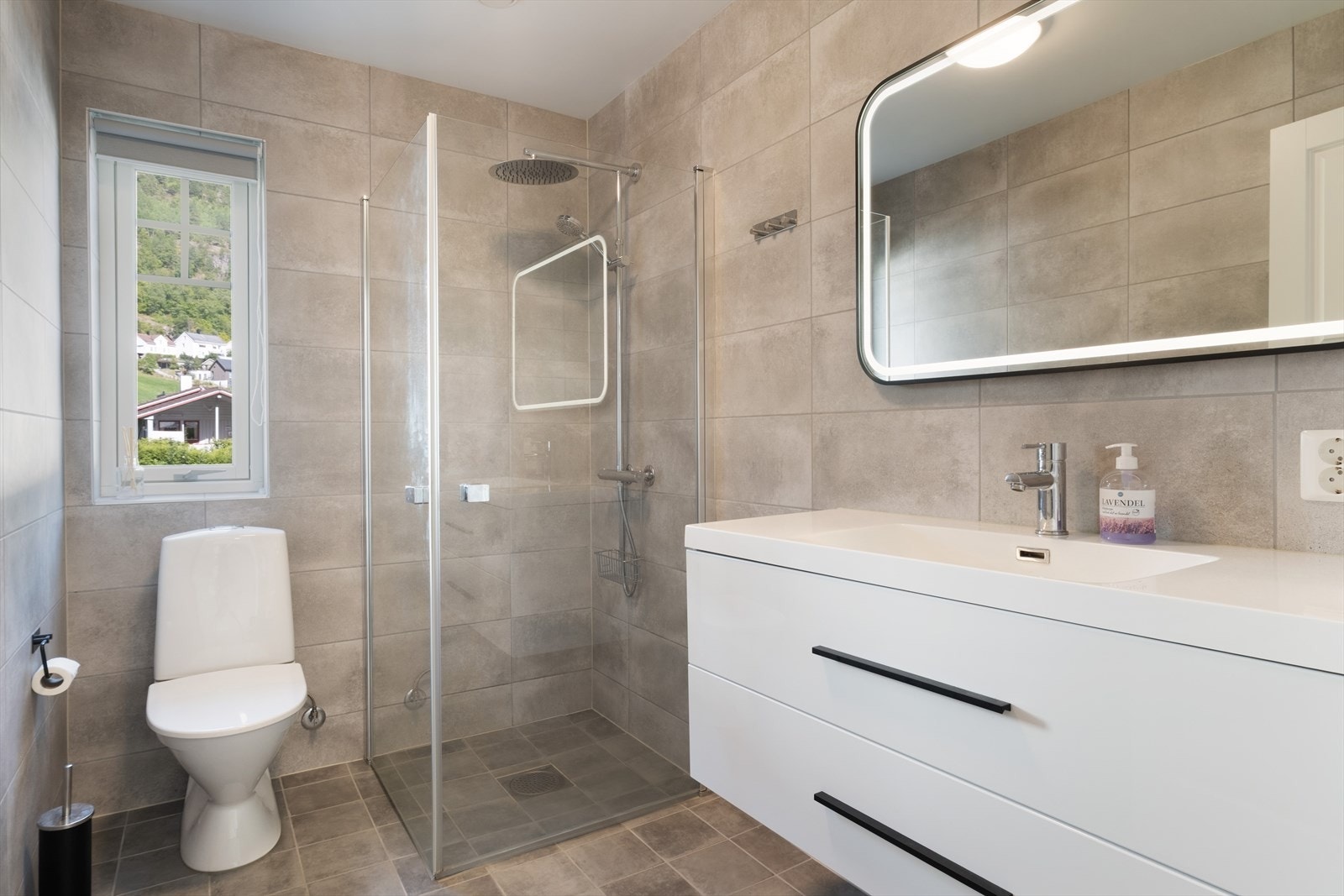 Badet har flislagt golv med elektriske varmekablar og måla himling. Galleribilde