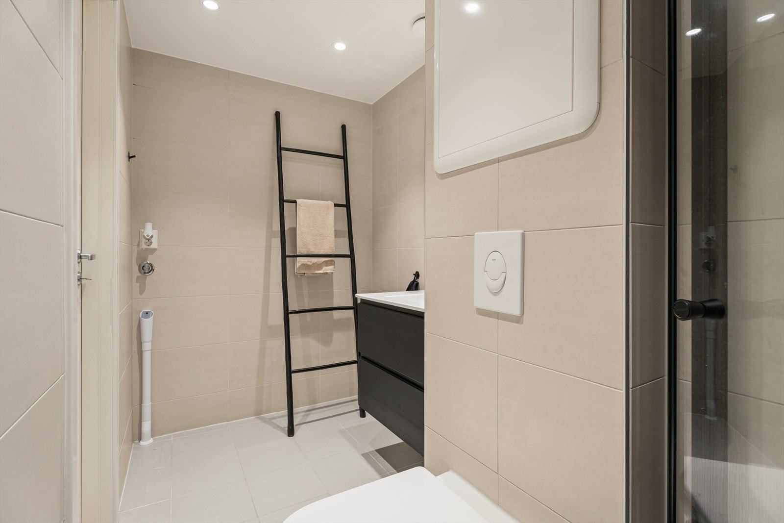 Her får du en moderne og innbydende atmosfære, med gulvvarme og downlights som sørger for ekstra komfort i hverdagen. Baderomsinnredningen består av skap med glatte fronter, servant, klosett, dusj på gulv og opplegg for vaskemaskin. Galleribilde