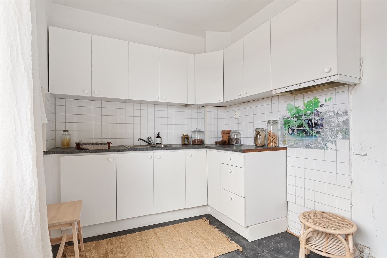Innredningen består av nøytrale, hvite fronter, fliser på bakvegg, laminert benkeplate og det er plass til frittstående hvitevarer. Galleribilde