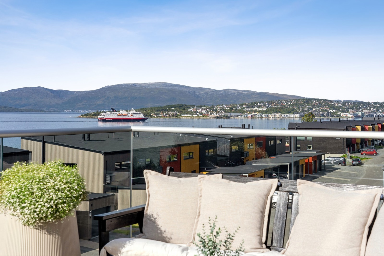 Panoramautsikt mot sjøen, fjellene og den ikoniske Hurtigruta på vei inn til Tromsø. Galleribilde