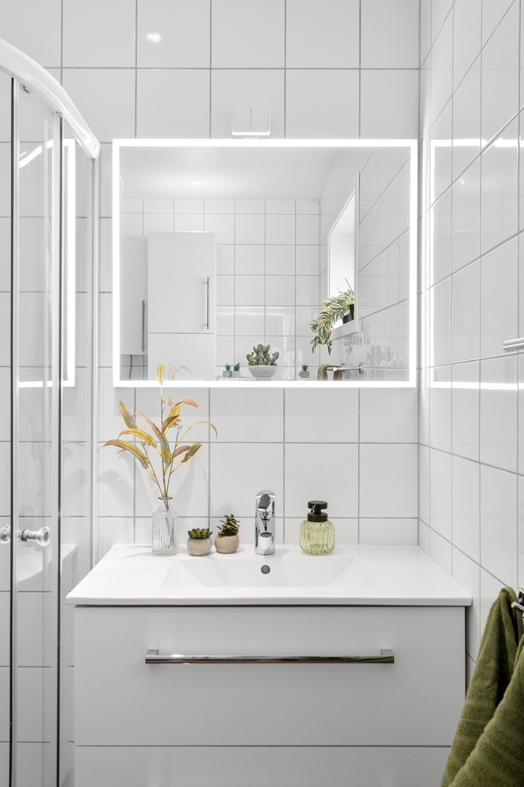 Baderomsinnredning med heldekkende servant og speil med integrert belysning. Galleribilde