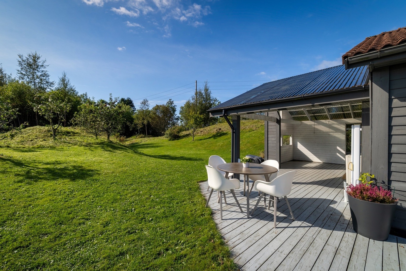 Ute er det flere soner. Her er det plass til trampoline, fotballmål, lekestue, kjøkkenhage og lange sommerdager ute - uten at det føles trangt. Galleribilde