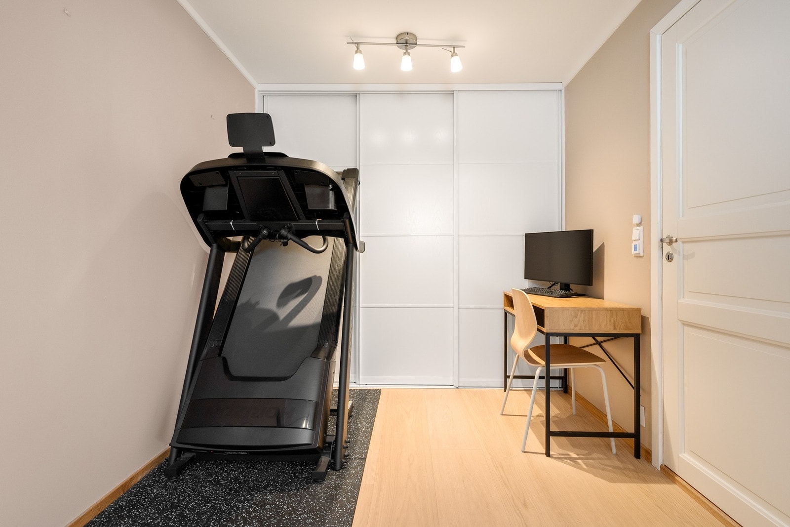 Romslig og anvendelig kjellerstue, i dag innredet med både kontor- og trimsone, samt praktisk skyvedørsgarderobe med god oppbevaringsplass. Galleribilde