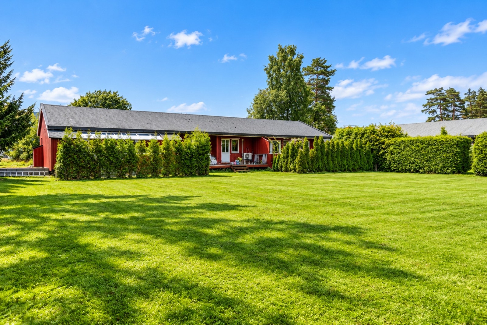Stor og brukervennlig gressplen foran eiendommen (bildet er redigert med AI) Galleribilde