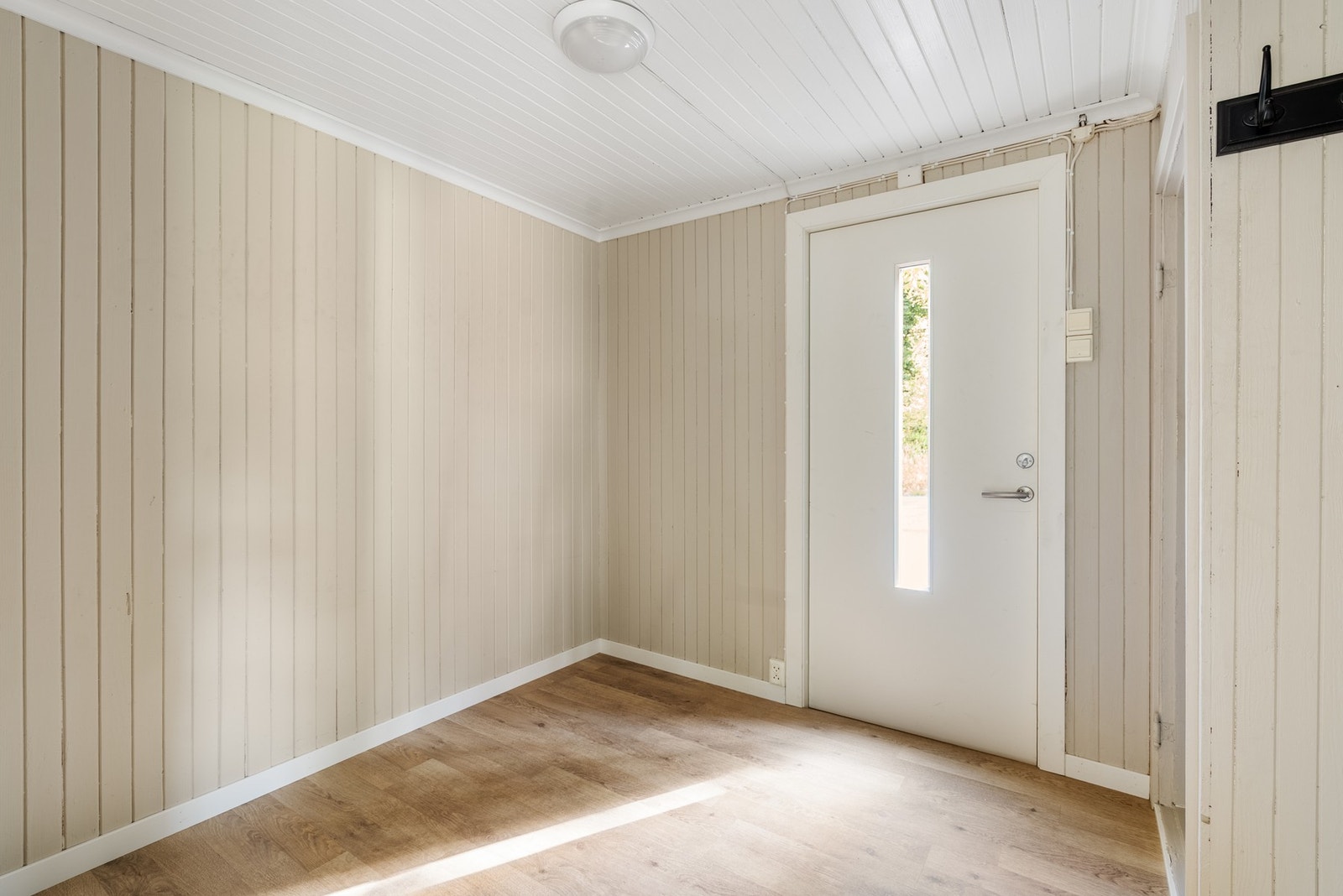 Innenfor døren har du lys og nylig malt entré med panel på vegger og tak, samt fin slitesterk laminat på gulvet Galleribilde