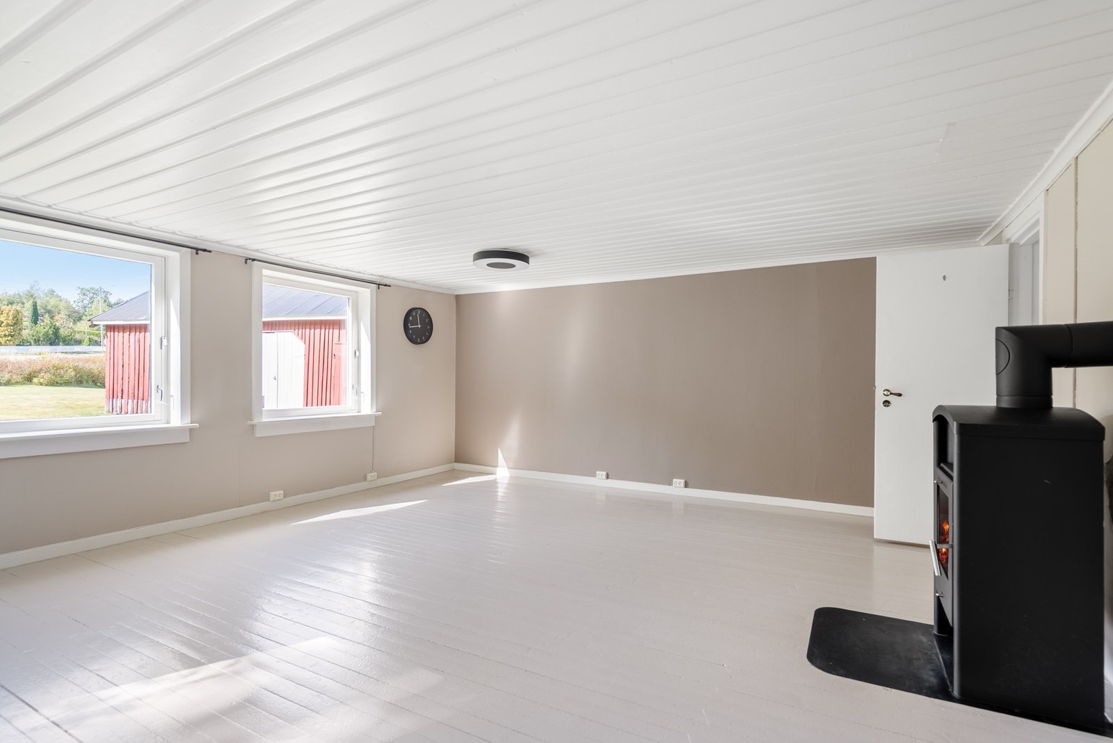 Tidløse, varme fargetoner kombineres med tregulv og panel i taket, og skaper et harmonisk og innbydende uttrykk Galleribilde