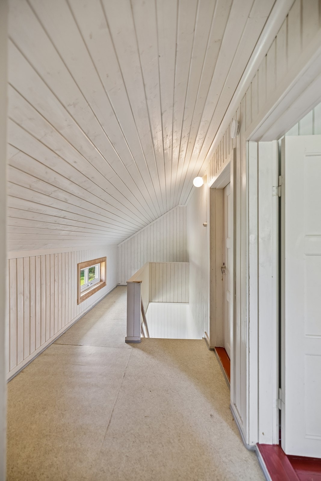 Gang i andreetasje med trappeadkomst, hvitmalt trepanel og lavt vindu. Galleribilde