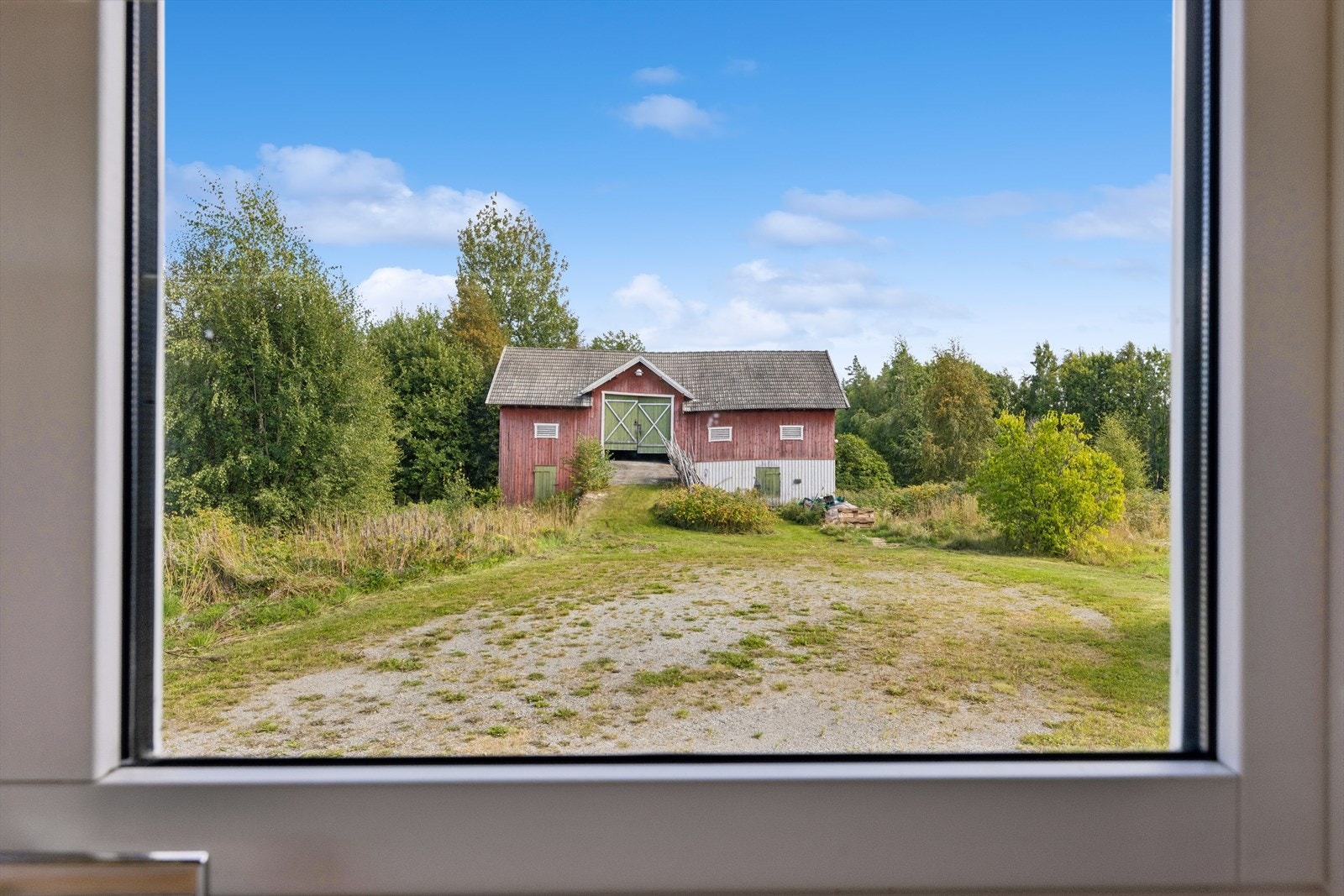 Utsyn fra boligen mot låven og det omkringliggende kulturlandskapet. Galleribilde