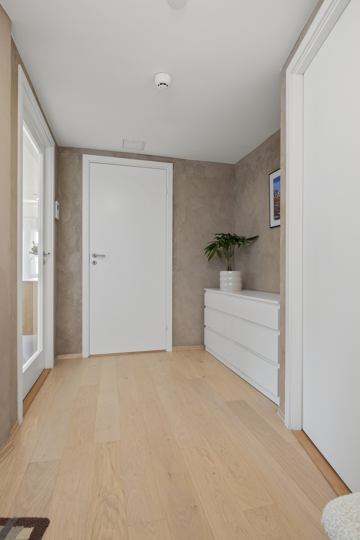 Entreen har lys parkett og malte vegger, og fremstår ryddig og innbydende. Galleribilde