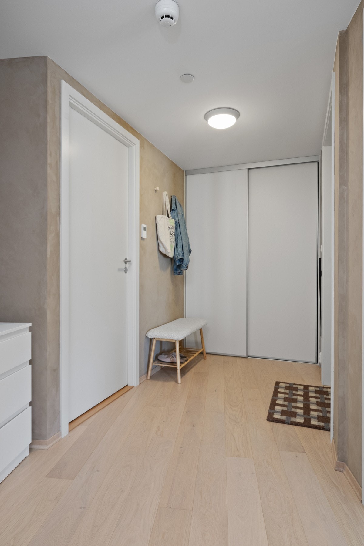 Entreen har garderobeskap og en liten sittebenk, praktisk for av- og påkledning. Galleribilde