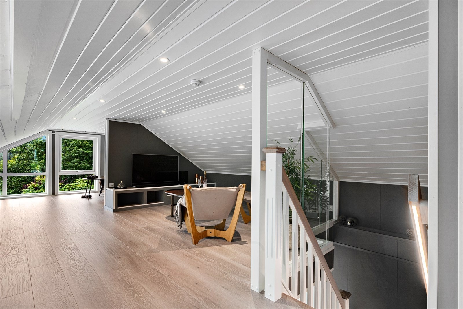Loftsetasjen er innreidd som ekstra opphaldsrom, med glasrekkverk og lyslist i trappa. Galleribilde