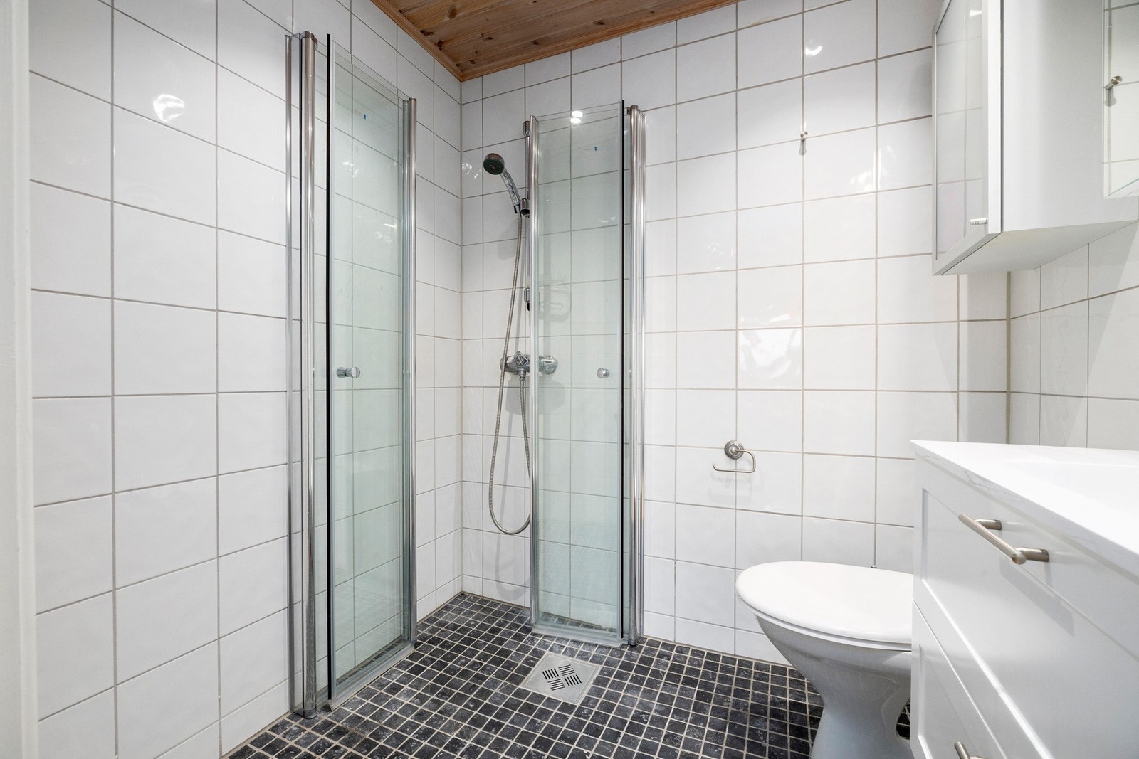 Helfliset baderom med gulvvarme og trepanel med downlights i himling Galleribilde