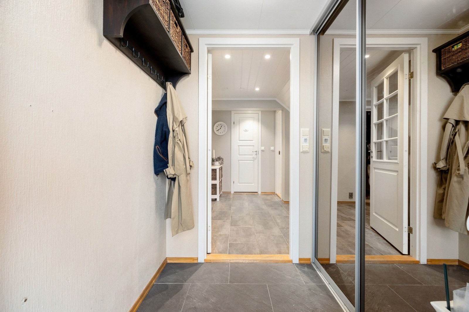 Entré med praktiske fliser på gulv og godt med oppbevaring for yttertøy og sko i skyvedørsgarderobe Galleribilde