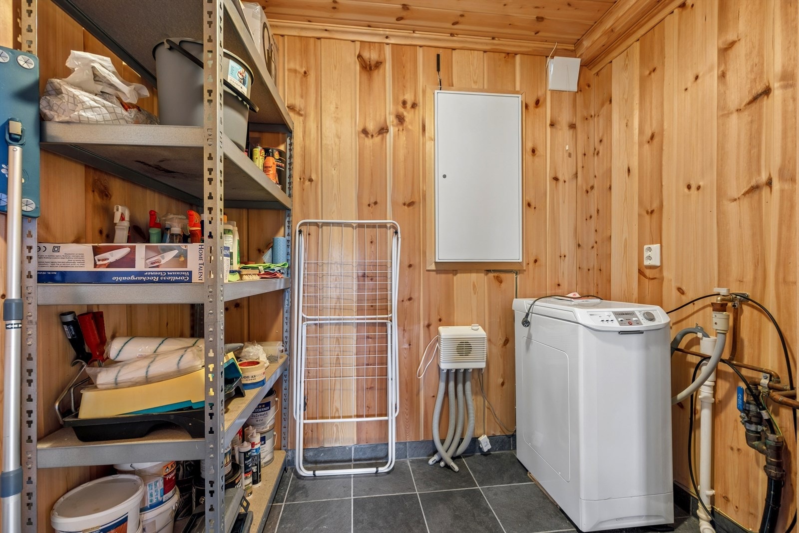 Praktisk vaskerom med flislagt gulv, elektriske varmekabler og opplegg for vaskemaskin. Galleribilde