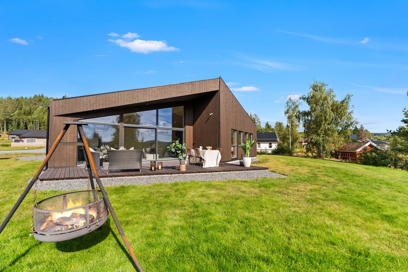 Fra hagen kommer boligens særpreg virkelig frem - en moderne enebolig som åpner seg mot solen og utearealene. Galleribilde