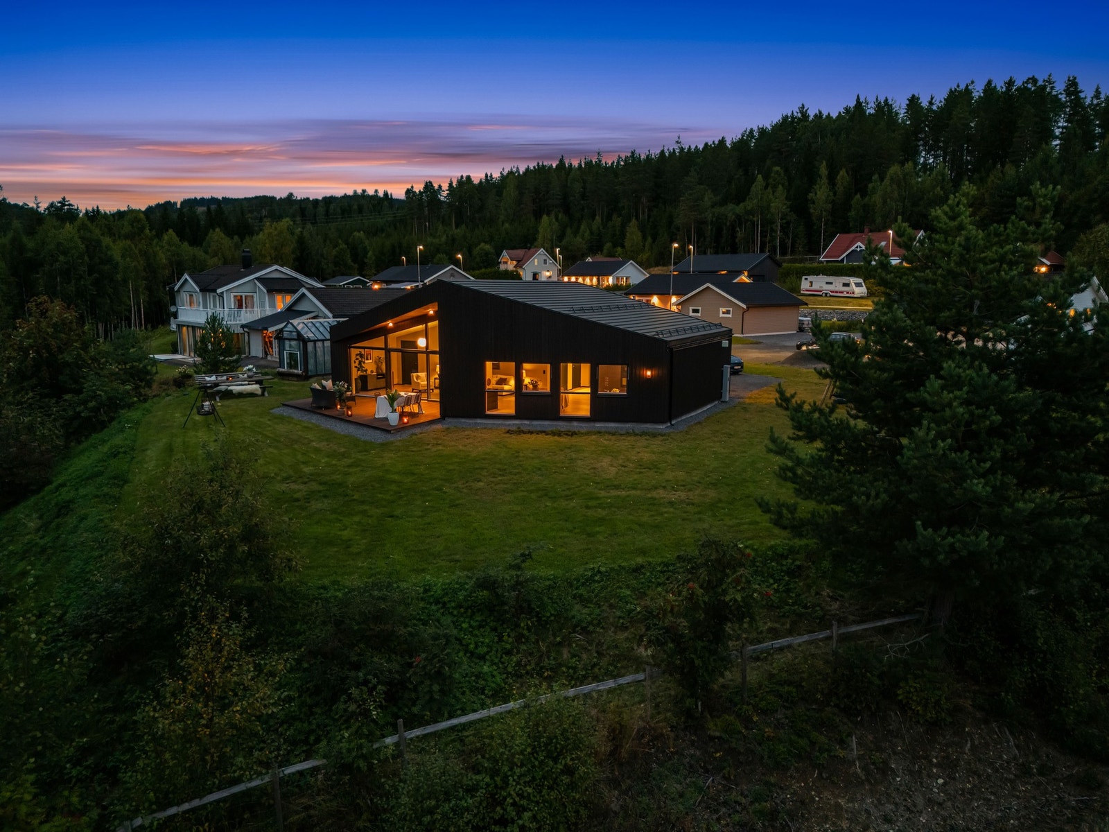 Når kvelden senker seg, viser boligen en helt annen side - varmt lys, åpen himmel og en stemningsfull ramme rundt hjemmet. Galleribilde