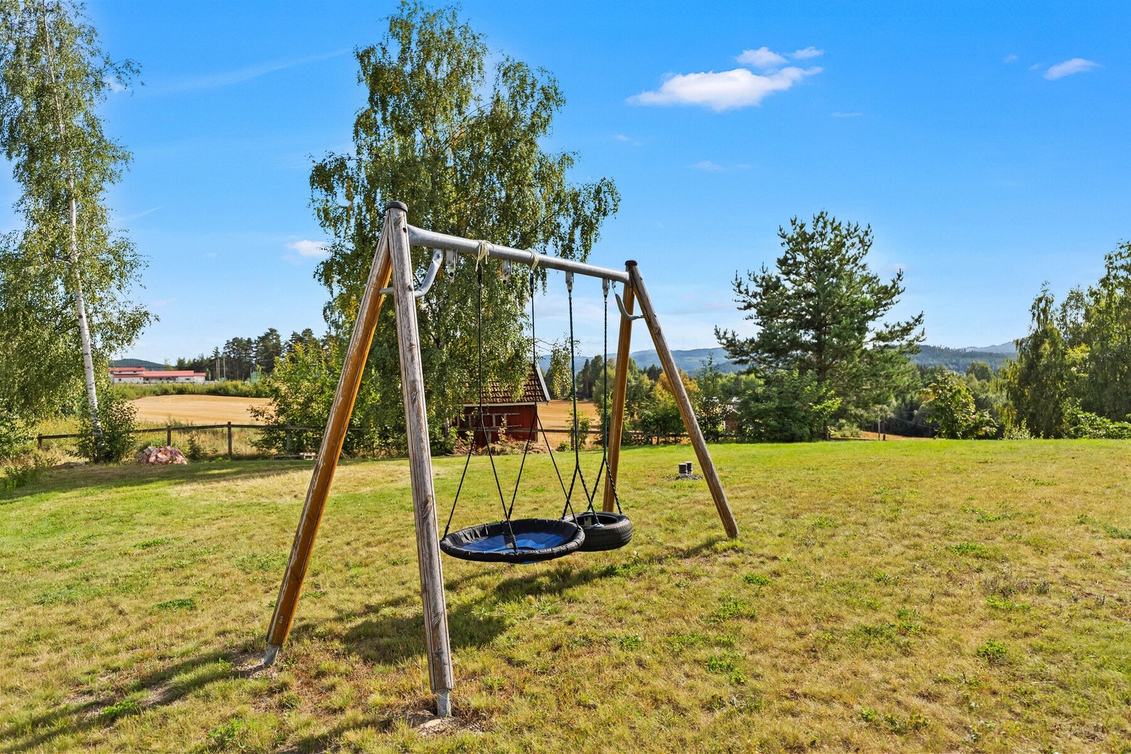 En hage laget for å brukes. Her er det allerede huskestativ, og fortsatt rikelig med plass til lek, spill og sommeraktiviteter. Galleribilde