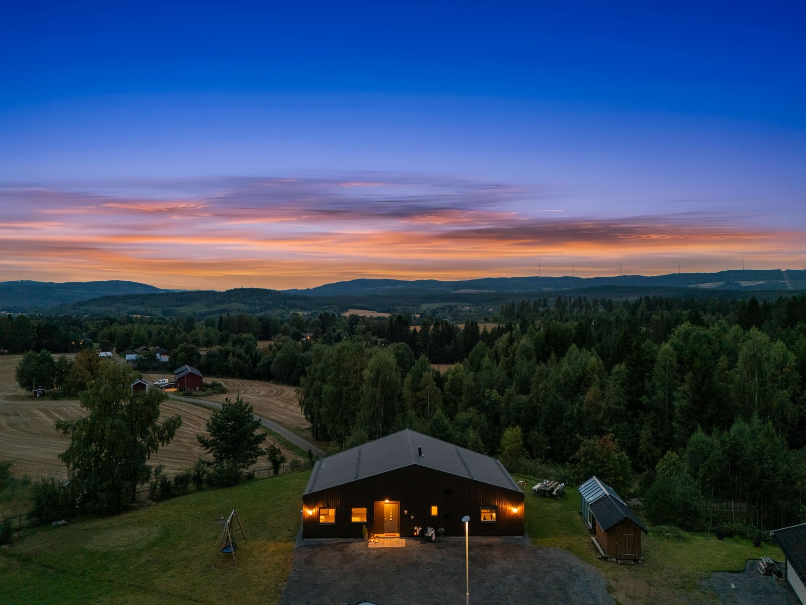 Dette er utsikten du kan avslutte dagen med - åpen himmel, åser i horisonten og boligen som lyser varmt i landskapet. Galleribilde