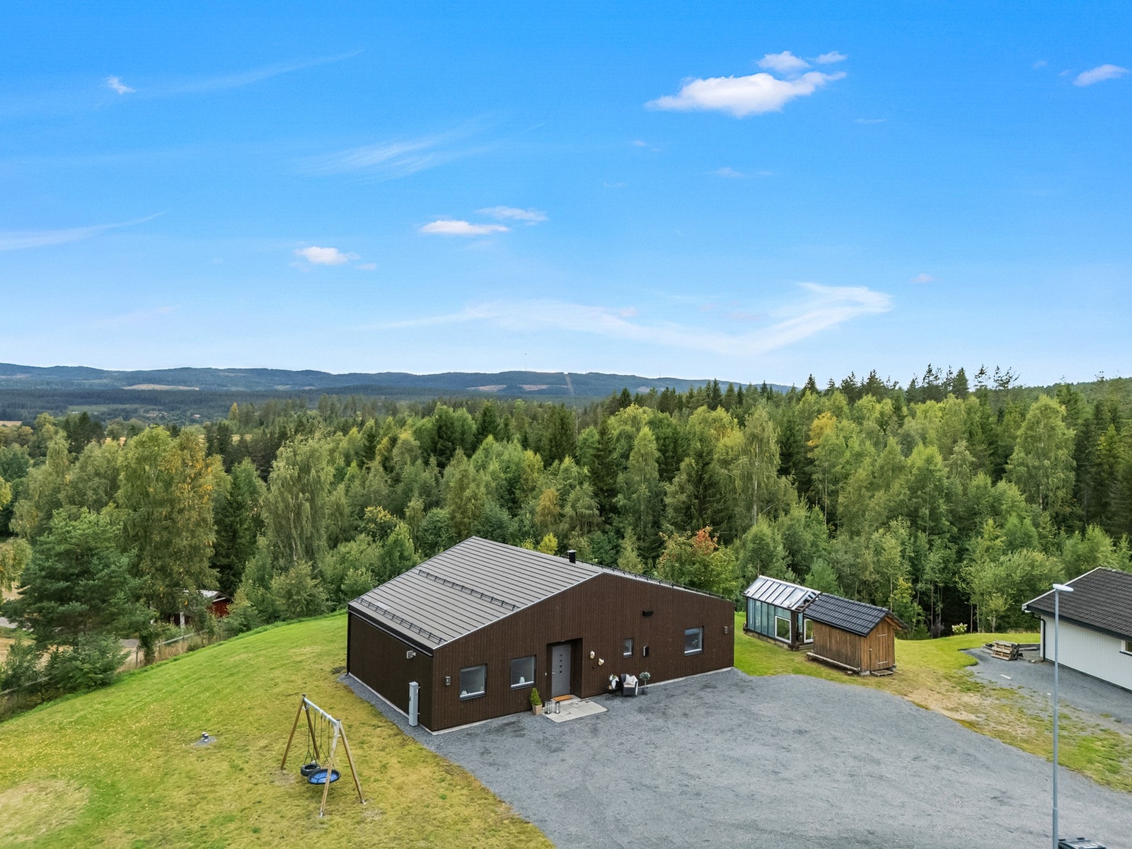 Her ser man virkelig hvor mye plass eiendommen byr på - boligen ligger luftig til med store grøntarealer og naturen tett rundt seg. Galleribilde