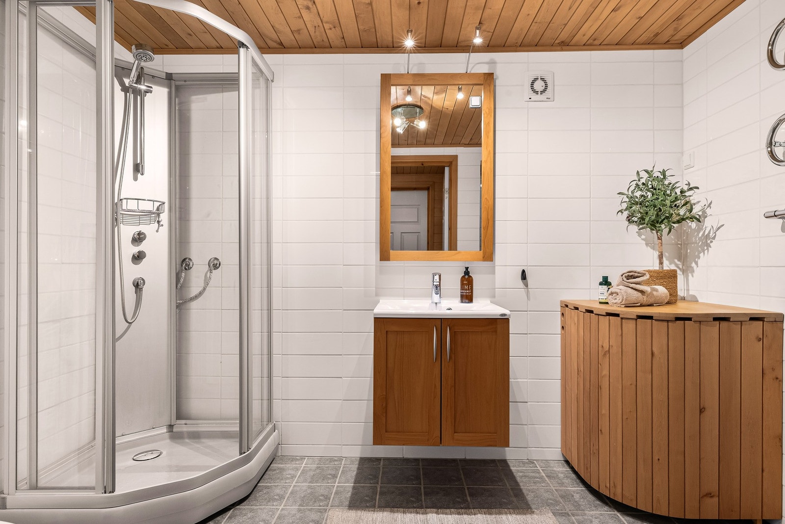 Romslig bad innredet med dusjkabinet, servant og WC Galleribilde