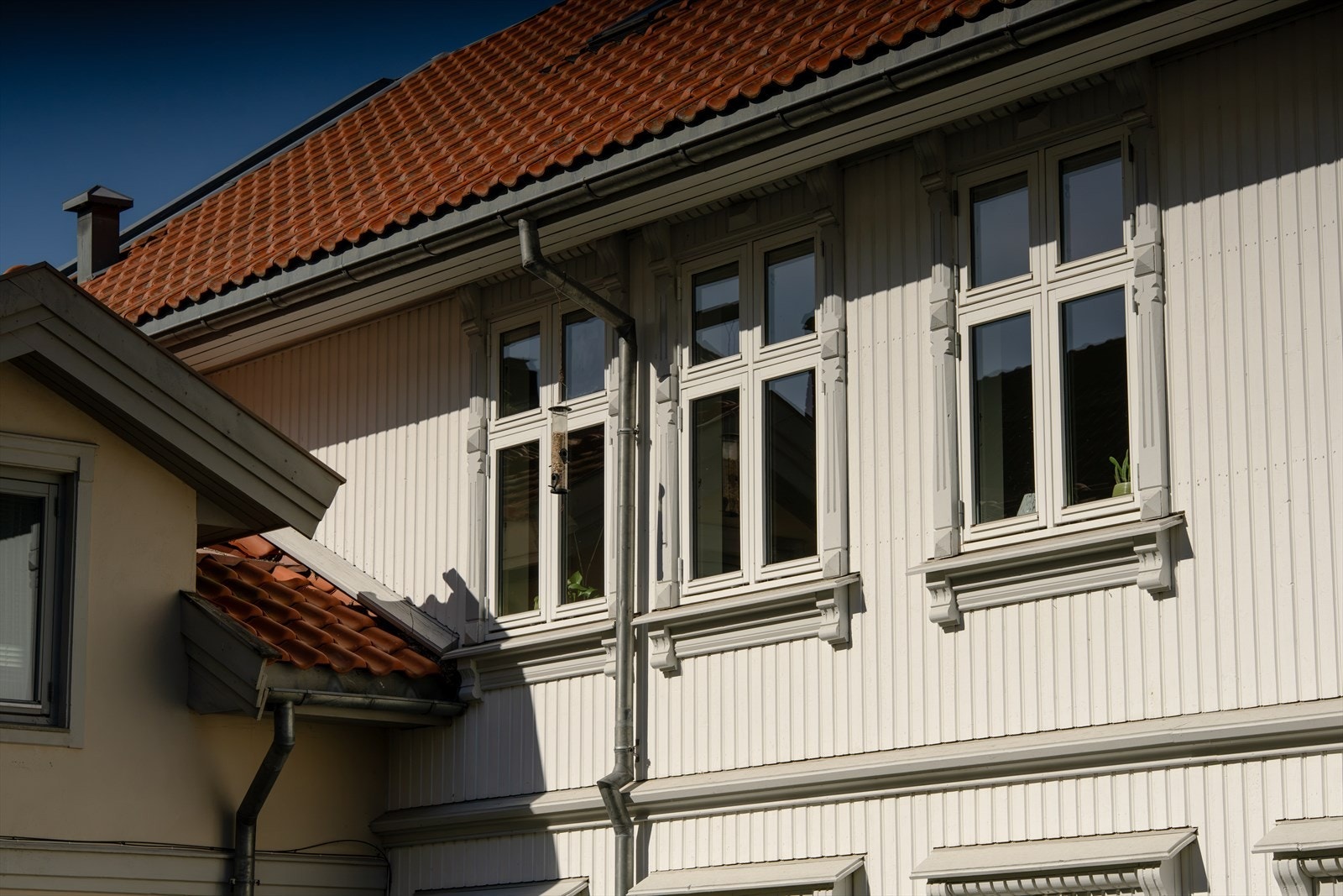 Bygningen har stående bordkledning, teglsteinsdekket tak og sinkbeslag. Galleribilde