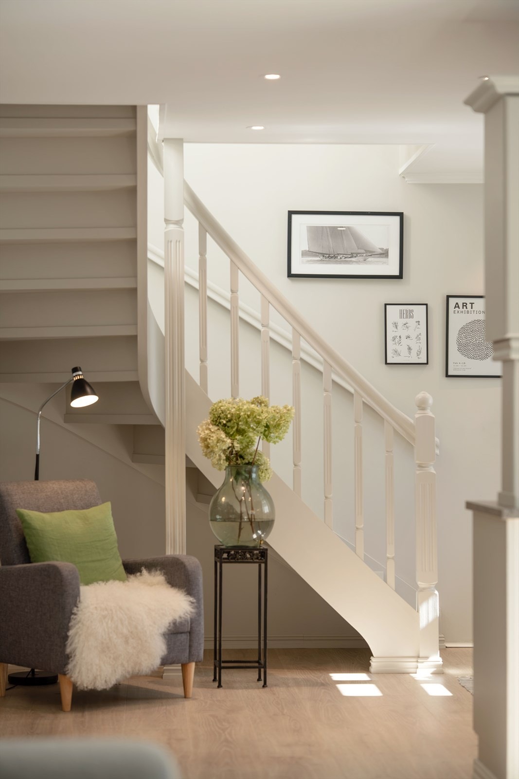 Den hvitmalte tretrappen reiser seg sentralt i oppholdsrommet. Galleribilde