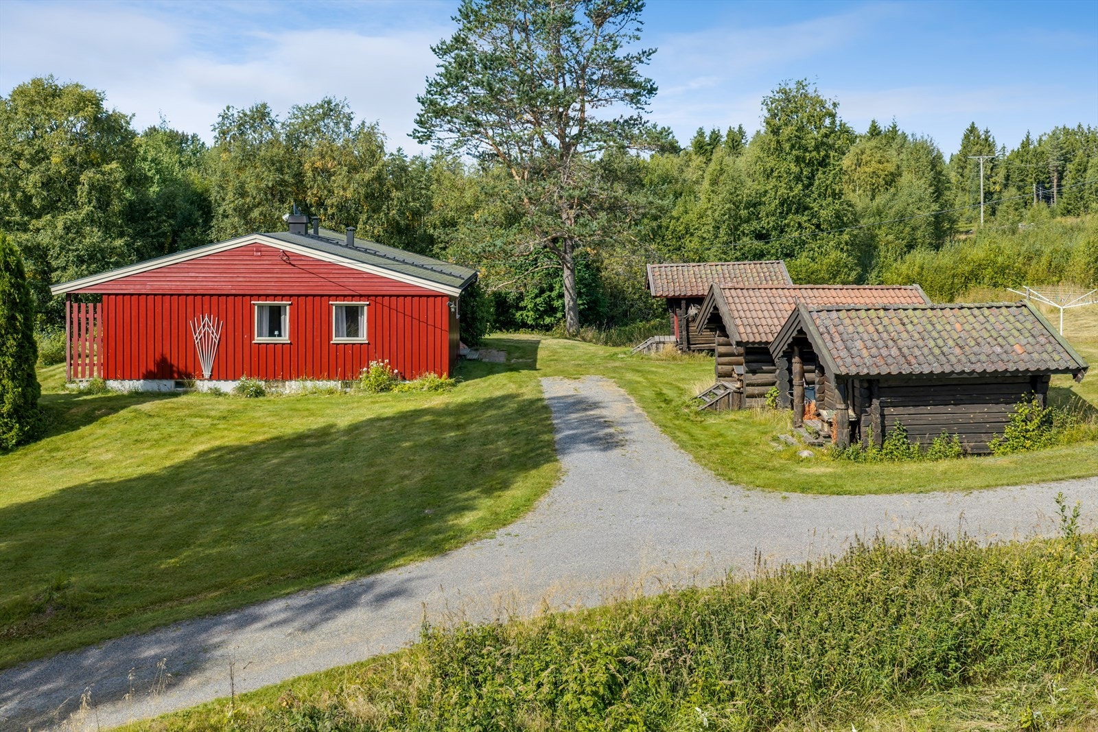 Landlig småbruk med enebolig, låve og flere stabbur på en stor, usjenert tomt. Galleribilde