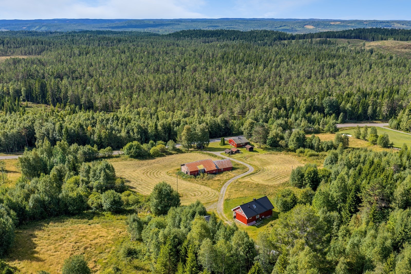 Det er skog på begge sider av boligtunet. Den røde eneboligen nederst i bildet er utskilt og medfølger ikke Galleribilde