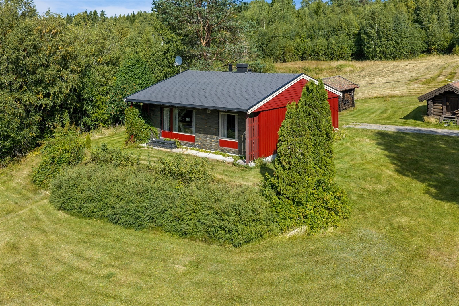 Eneboligen har fasader kledd med tømmermannskledning og skiferfliser. Galleribilde