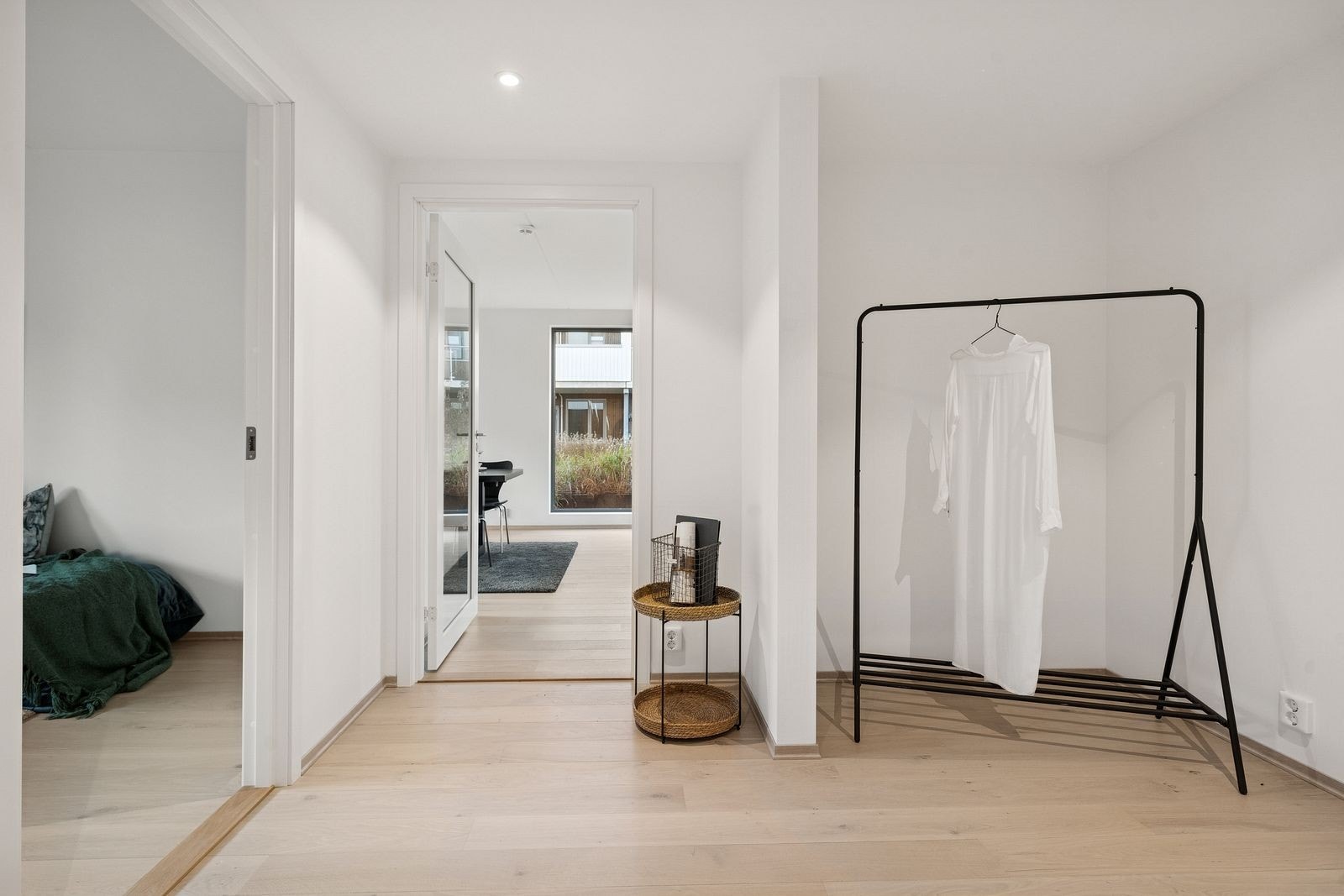 Romslig gang med plass til å henge fra seg ytterjakker. Det er avsatt egen nisje i gangen med mulighet for å sette inn garderobeskap eller skyvedører. Inngang til bad rett til høyre i bildet. Gjesterom på venstre side før du går inn i stuen. Galleribilde