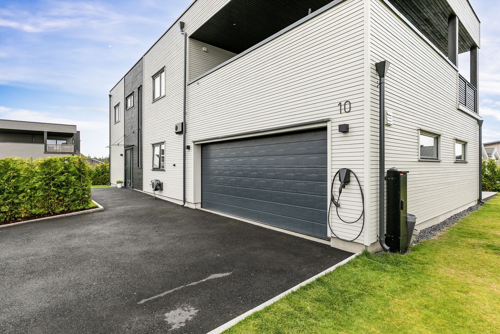 Lader til EL-bil montert innvendig i garasjen og utvendig på garasjevegg. Galleribilde