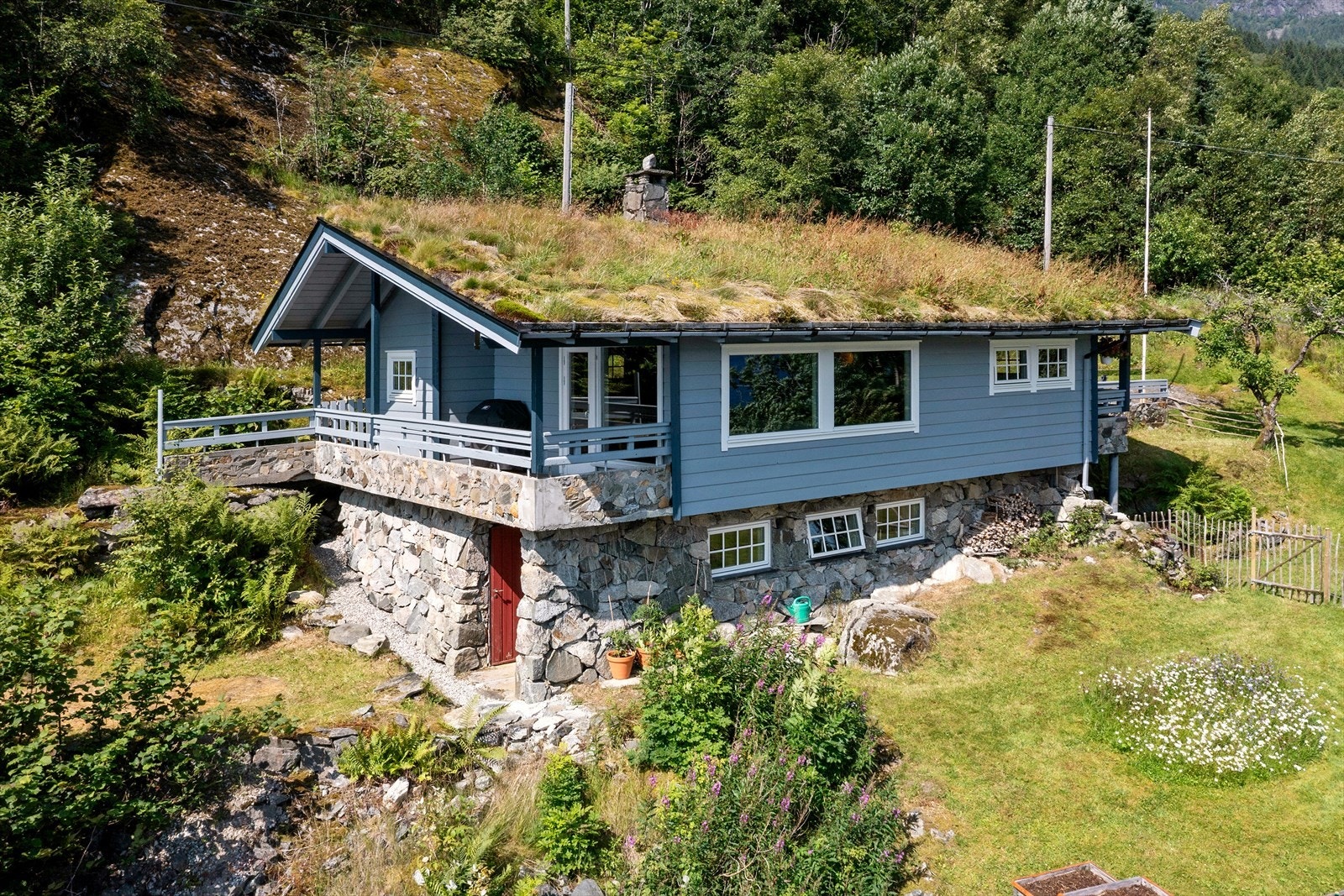 Fritidsbustaden har grunnmur forblenda med naturstein og tradisjonelt torvtak. Galleribilde