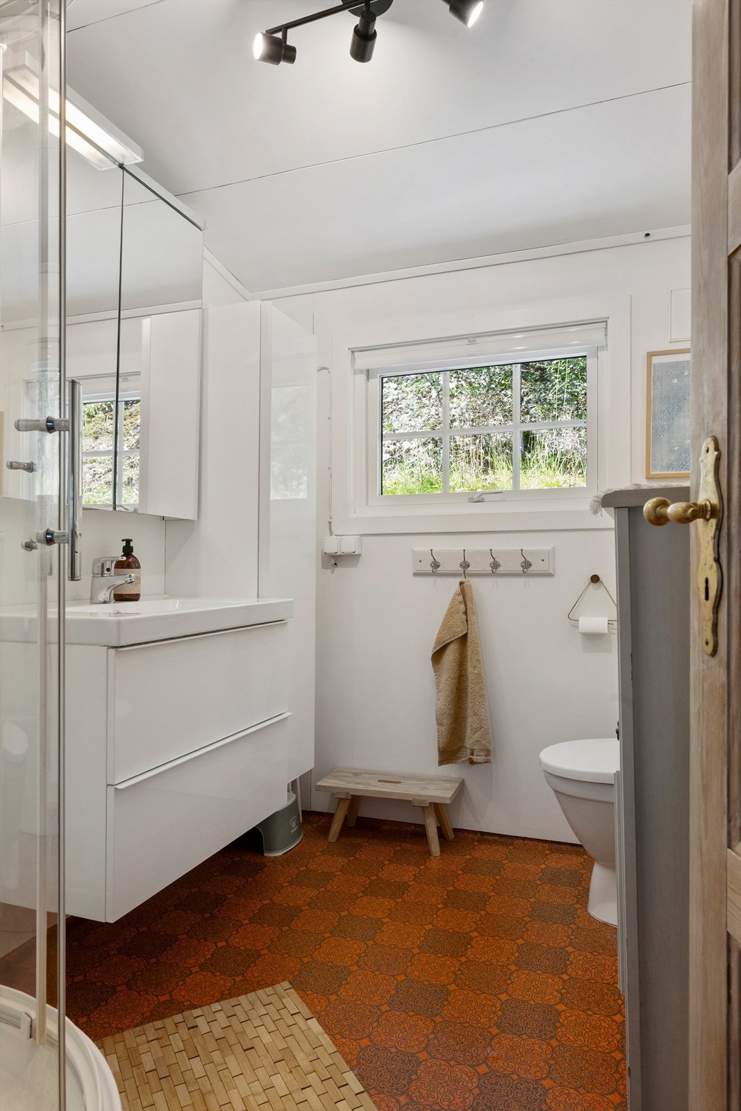Badet i 1. etasje er utstyrt med servant i underskåp, dusjkabinett og varmekablar. Galleribilde