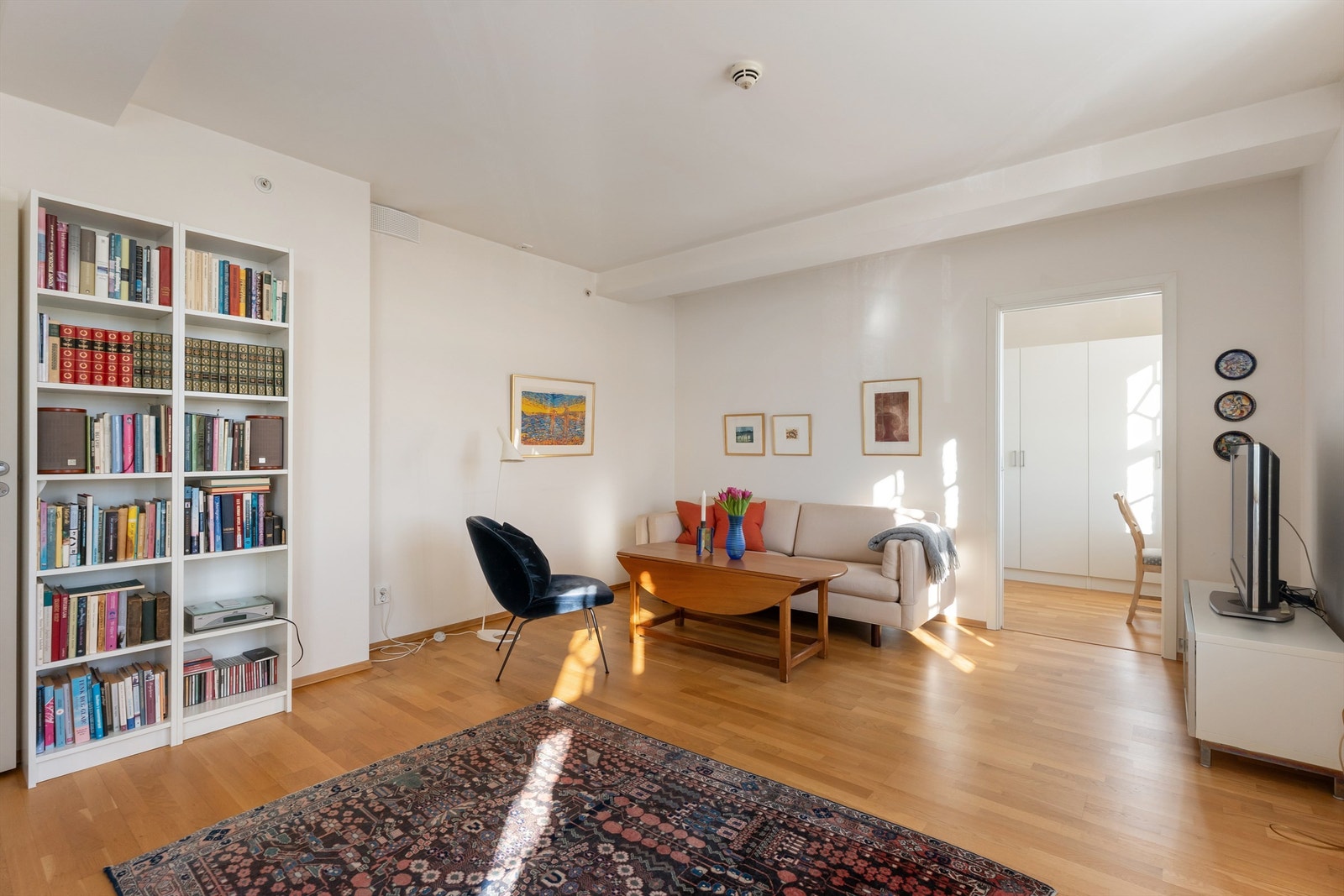 Gjennomgående parkett på gulv og malte, lyse flater danner et nøytralt utgangspunkt. Galleribilde