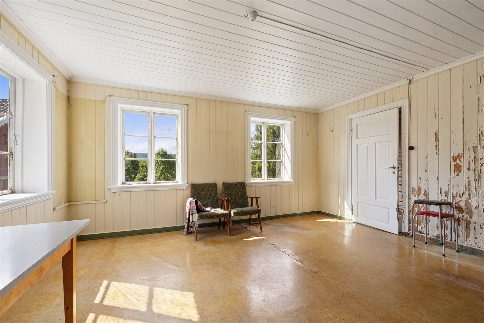 Stue 2 ligger på motsatt side av gangen. Rommet har eldre standard og bærer preg av alder og slitasje. Det er registrert fuktskader i rommet. Galleribilde