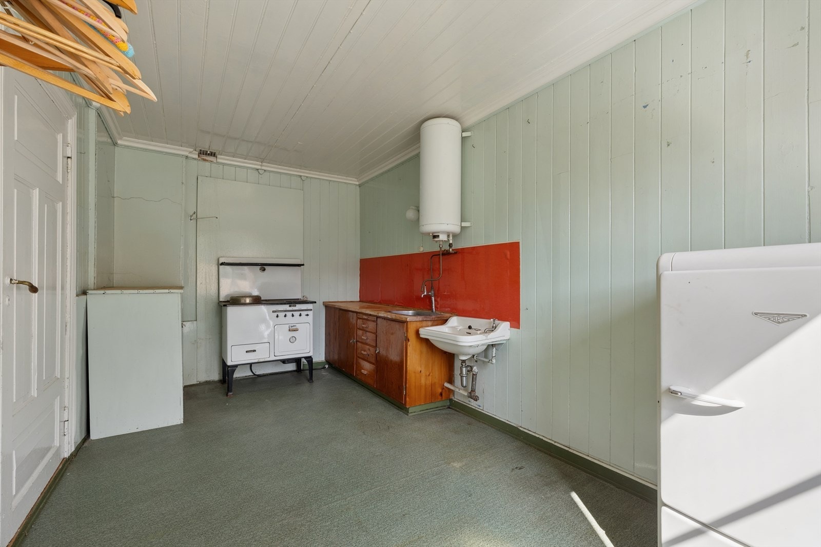 Kjøkken 2 har kjøkkeninnredning med glatte fronter og benkeplate i heltre. Kjøkkenet har eldre røropplegg og mangler avtrekksløsning. Galleribilde