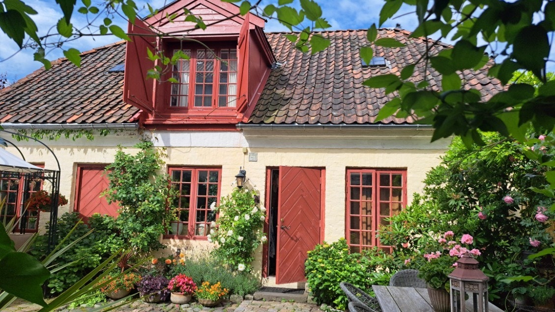 Ved inngangspartiet har dette bryggerhuset en nydelig privat hage - som er opparbeidet med nostalgisk stendekke og vakkert rammet inn av murvegger som kler arkitekturen Galleribilde