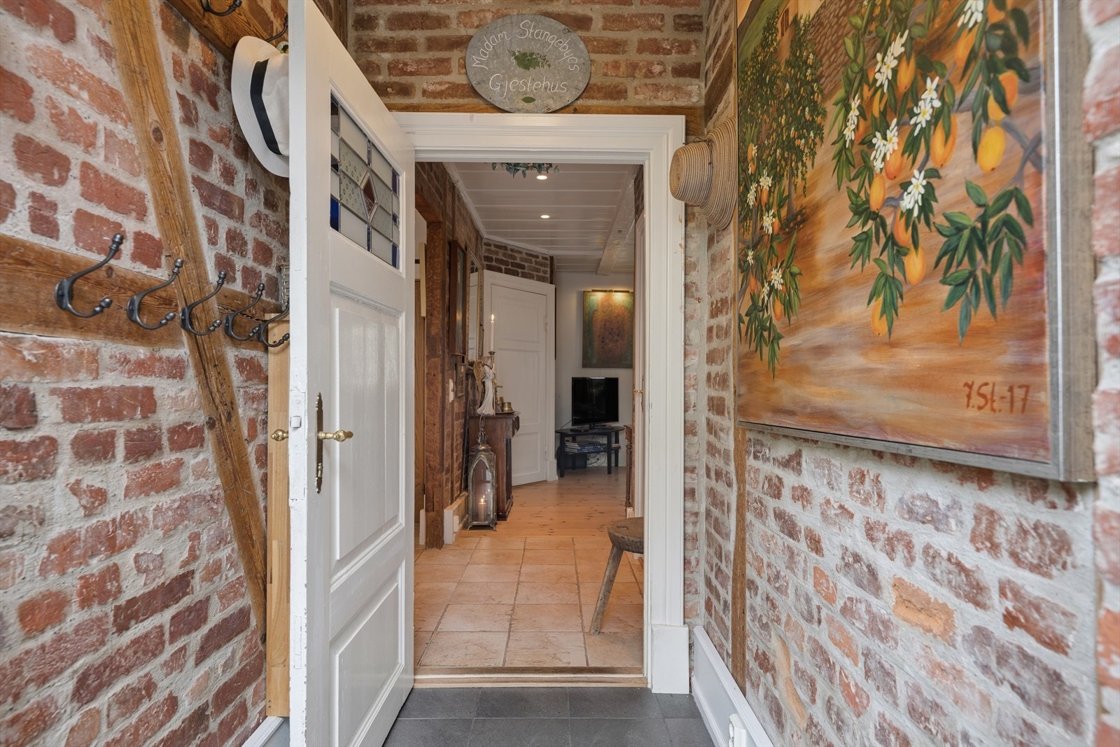 Man tar turen gjennom boligens vakre hage og til inngangspartiet der man møtes av praktisk entrè med flislagt gulv og varmekabler samt god plass til å henge av seg Galleribilde