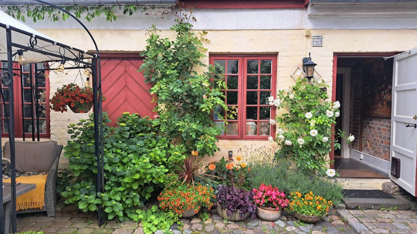 Den vakre beplantningen rammer inn boligen og skaper en sommeroase man sjelden ser lignende av Galleribilde